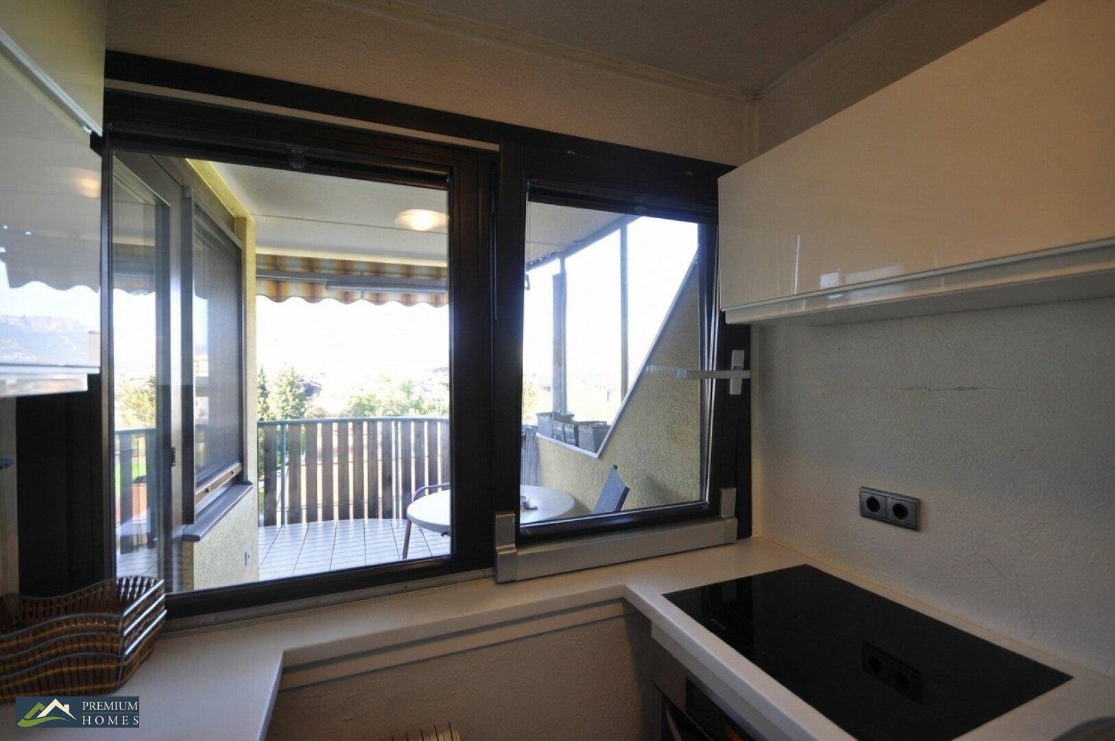 Wörgl 3 Zimmer Wohnung - Küchenfenster mit Blick auf Sitzgelegenheit am Balkon.