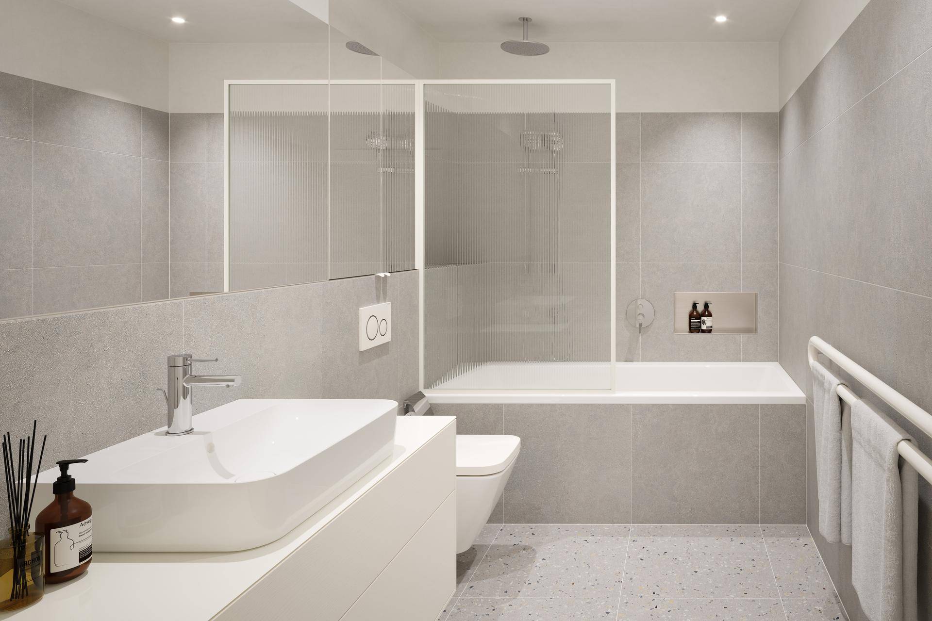 Modernes Badezimmer mit Badewanne, Dusche, wandhängendem WC und großformatigen grauen Fliesen.