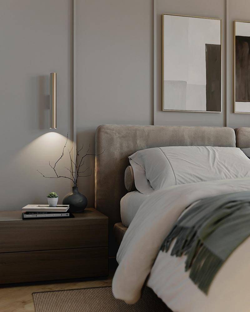 Modernes Schlafzimmer mit stilvollem Bett, Nachttisch und dezenter Wandbeleuchtung.