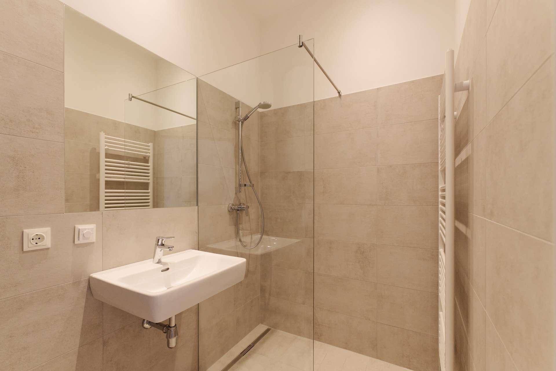 Modernes Badezimmer mit begehbarer Dusche, Einzelwaschbecken und beheiztem Handtuchhalter.