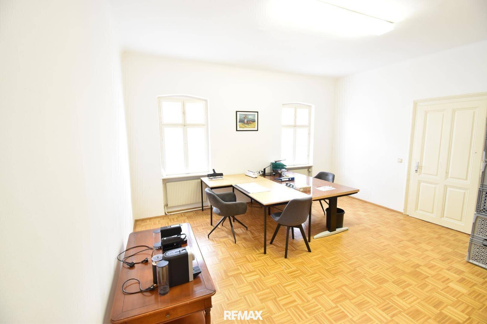 Helles Büro mit zwei Schreibtischen, modernen Stühlen und Parkettboden, ideal für produktives Arbeiten.