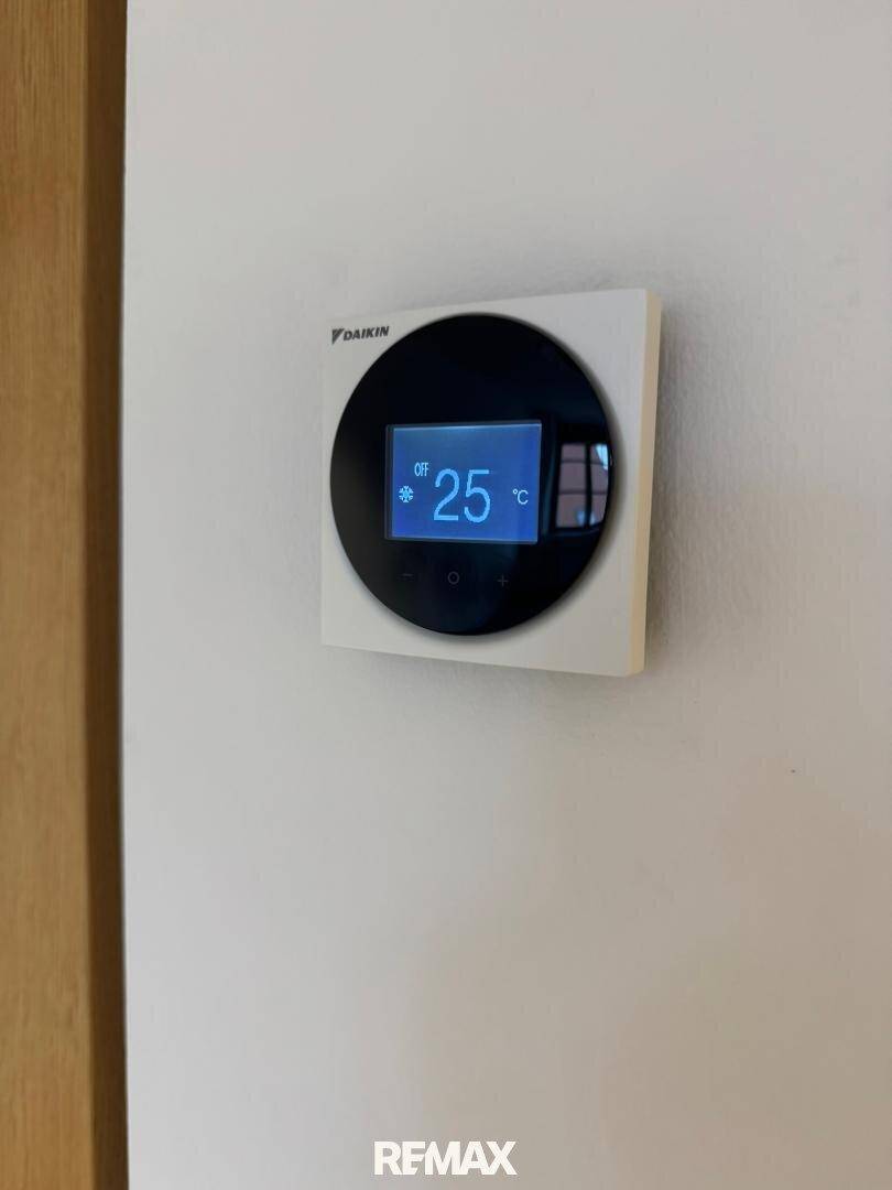 Nahaufnahme eines modernen Daikin-Thermostats zur Klimasteuerung.