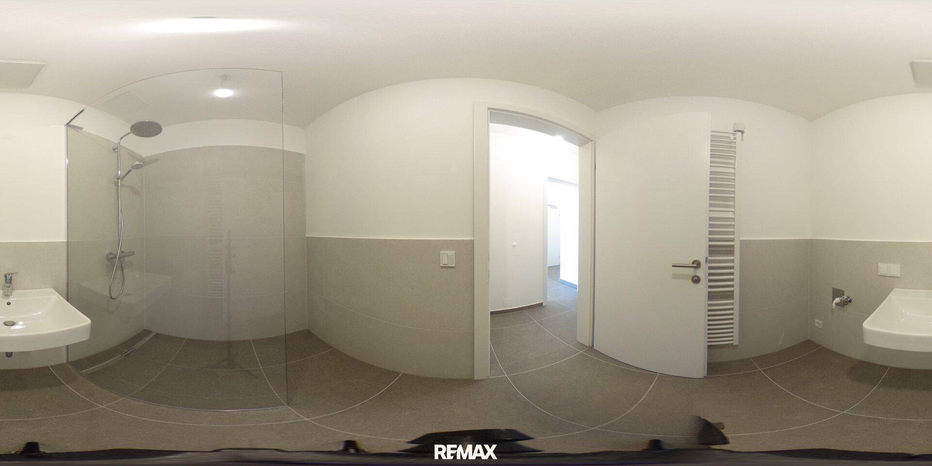 Panoramaansicht eines modernen Badezimmers mit ebenerdiger Dusche und Handtuchheizkörper.