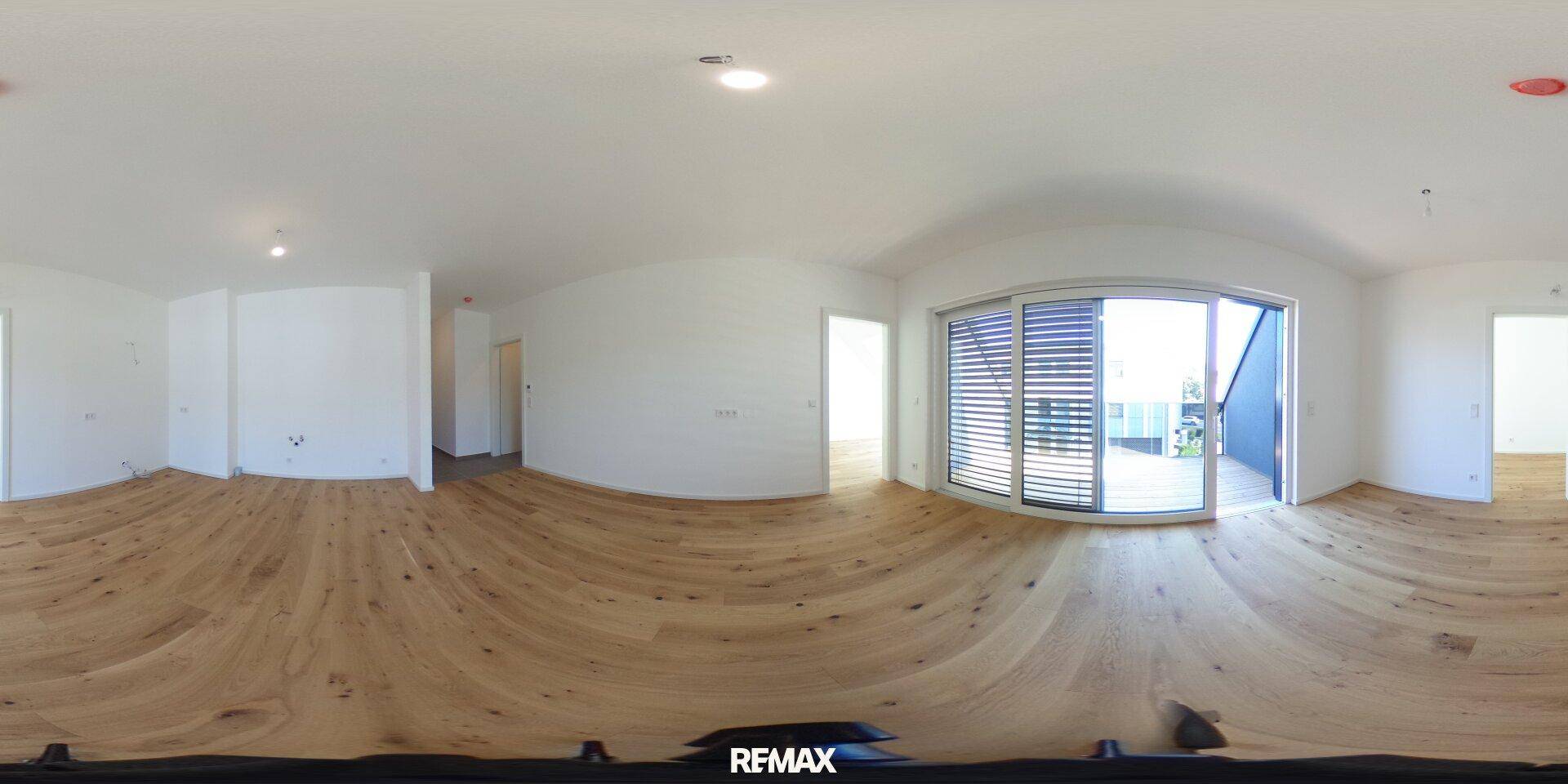 Panoramaansicht eines leeren Wohnzimmers mit Holzboden und Balkonzugang.