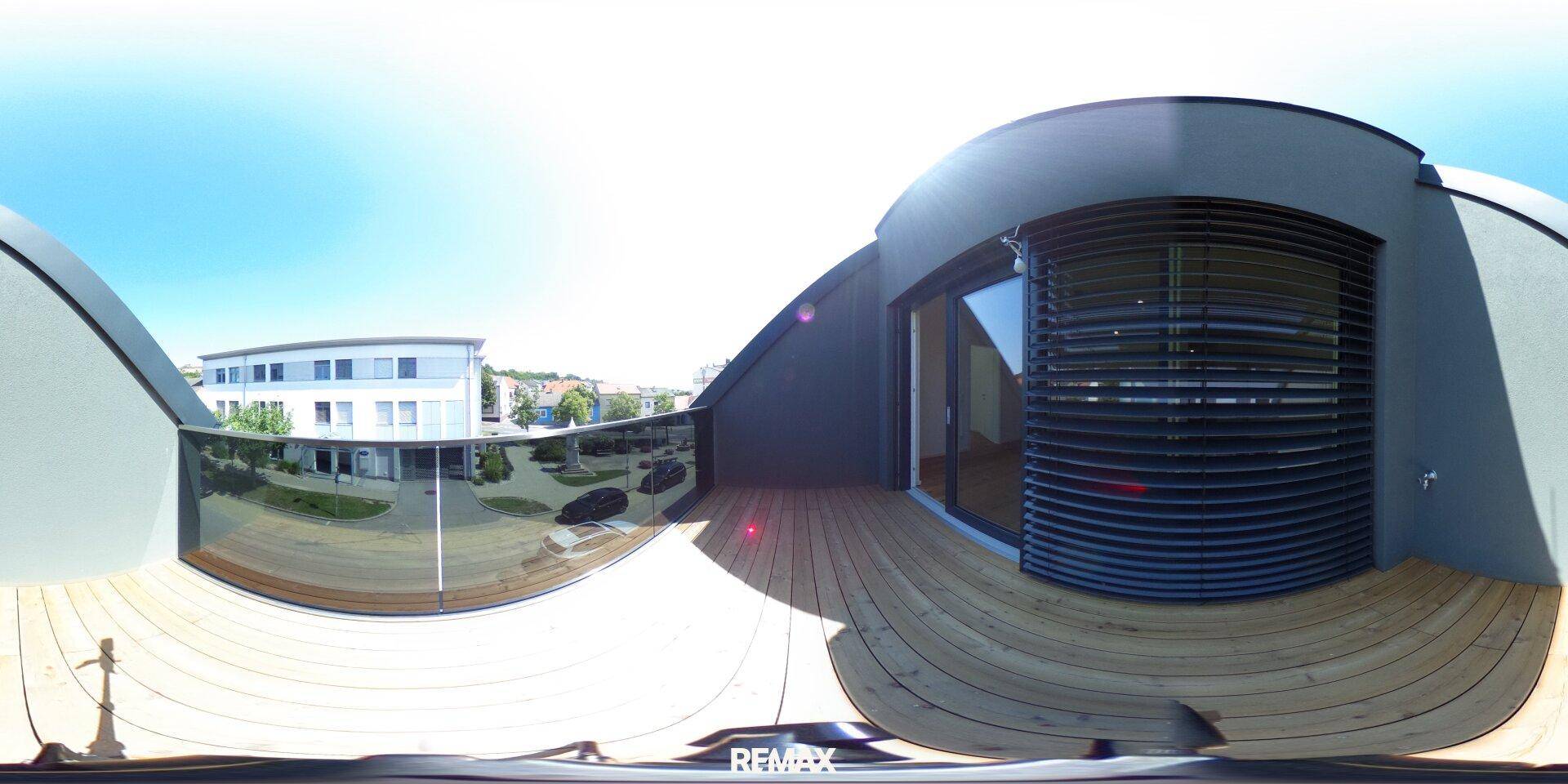 Panoramaansicht eines modernen Balkons mit Holzdeck und weitem Blick.