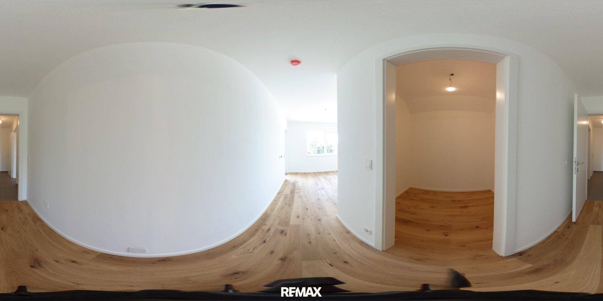 Panoramaansicht eines hellen Flurs mit Holzboden und Zugang zu weiteren Räumen.