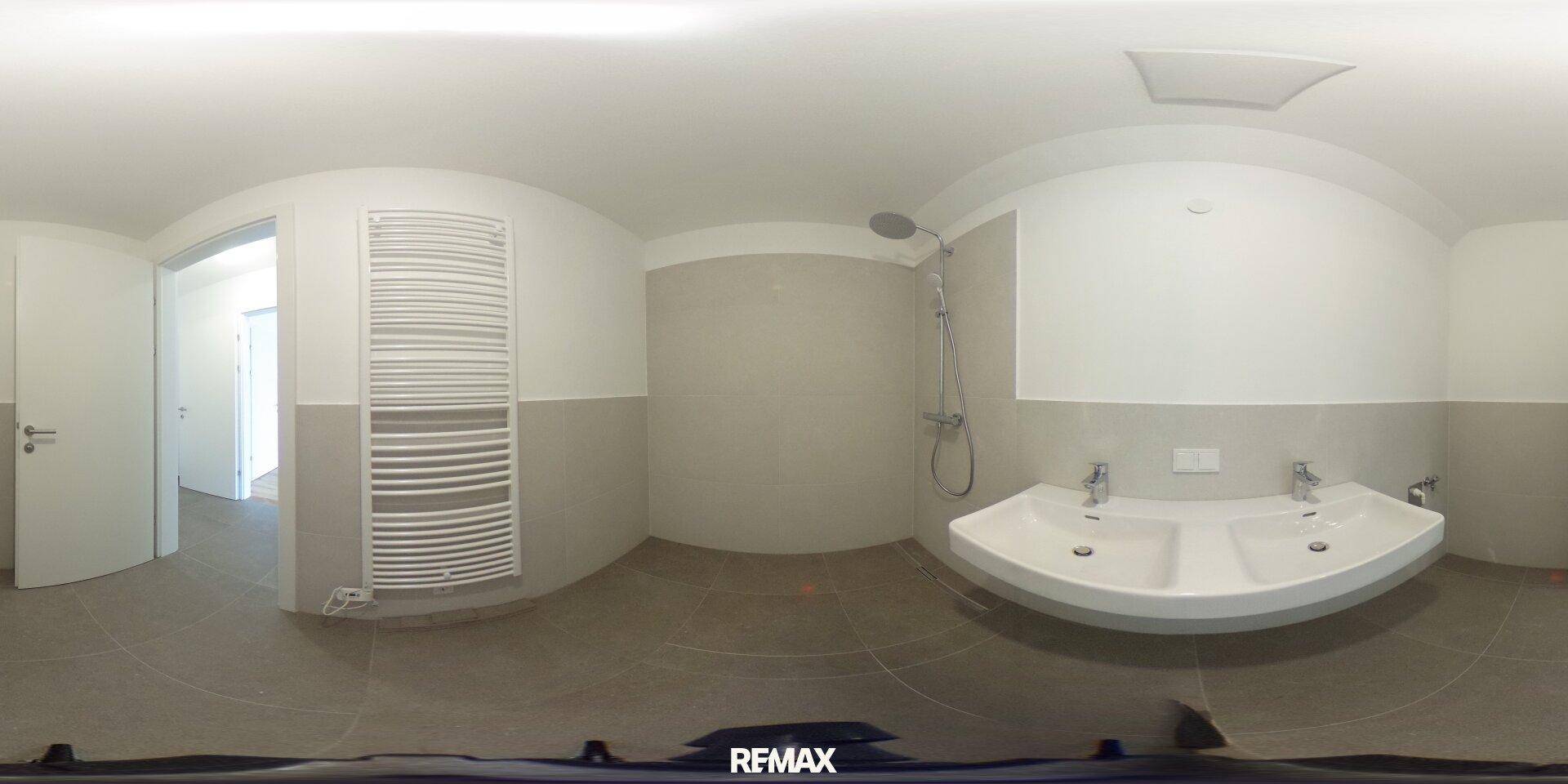 Panoramaansicht eines modernen Badezimmers mit Doppelwaschbecken und Dusche.