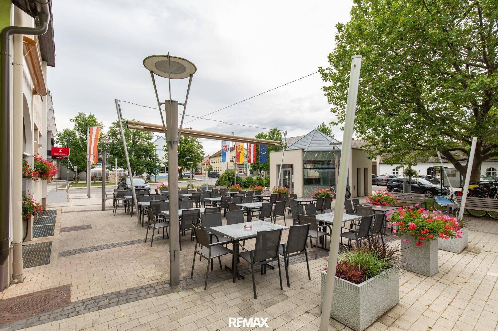 Weitläufige Außenterrasse eines Restaurants mit vielen Sitzgelegenheiten und Blick auf die Umgebung.