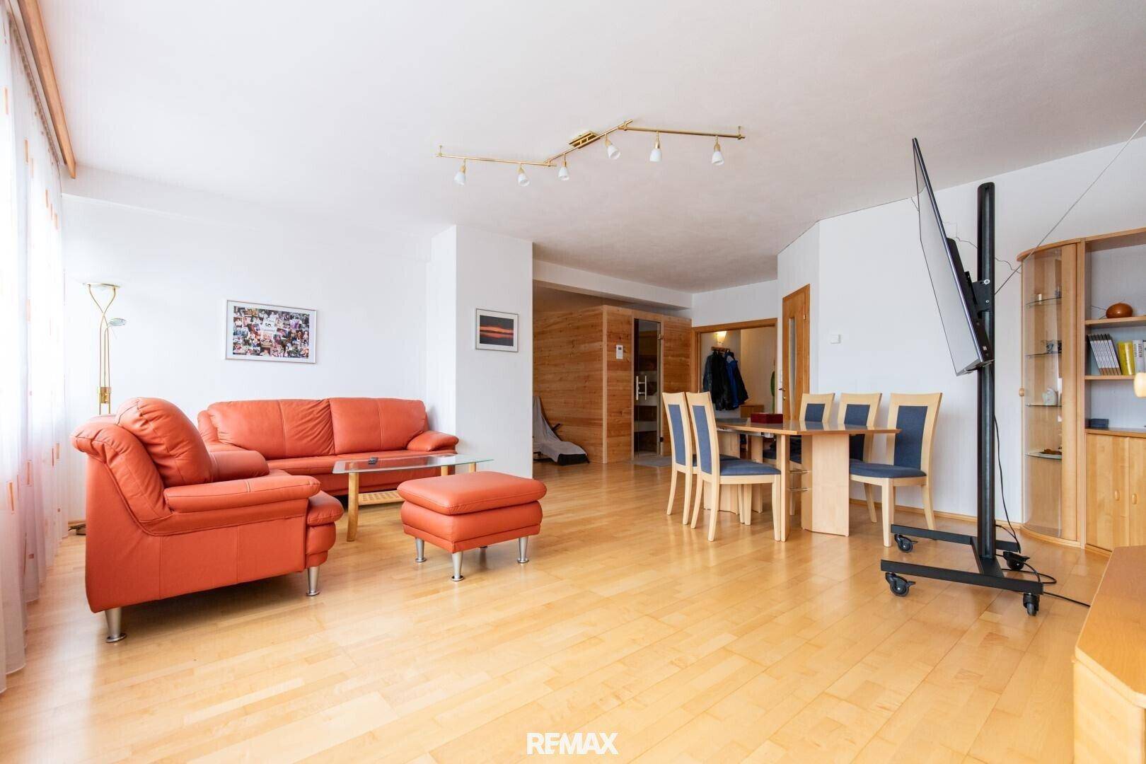 Geräumiger Wohn- und Essbereich mit hellem Holzboden, bequemen Sofas und einem Esstisch.