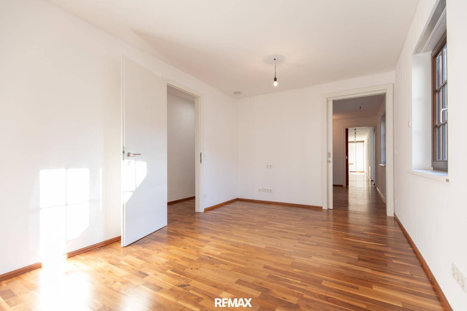 Geräumiges Zimmer mit Parkettboden und zwei Türen, vielseitig nutzbar.
