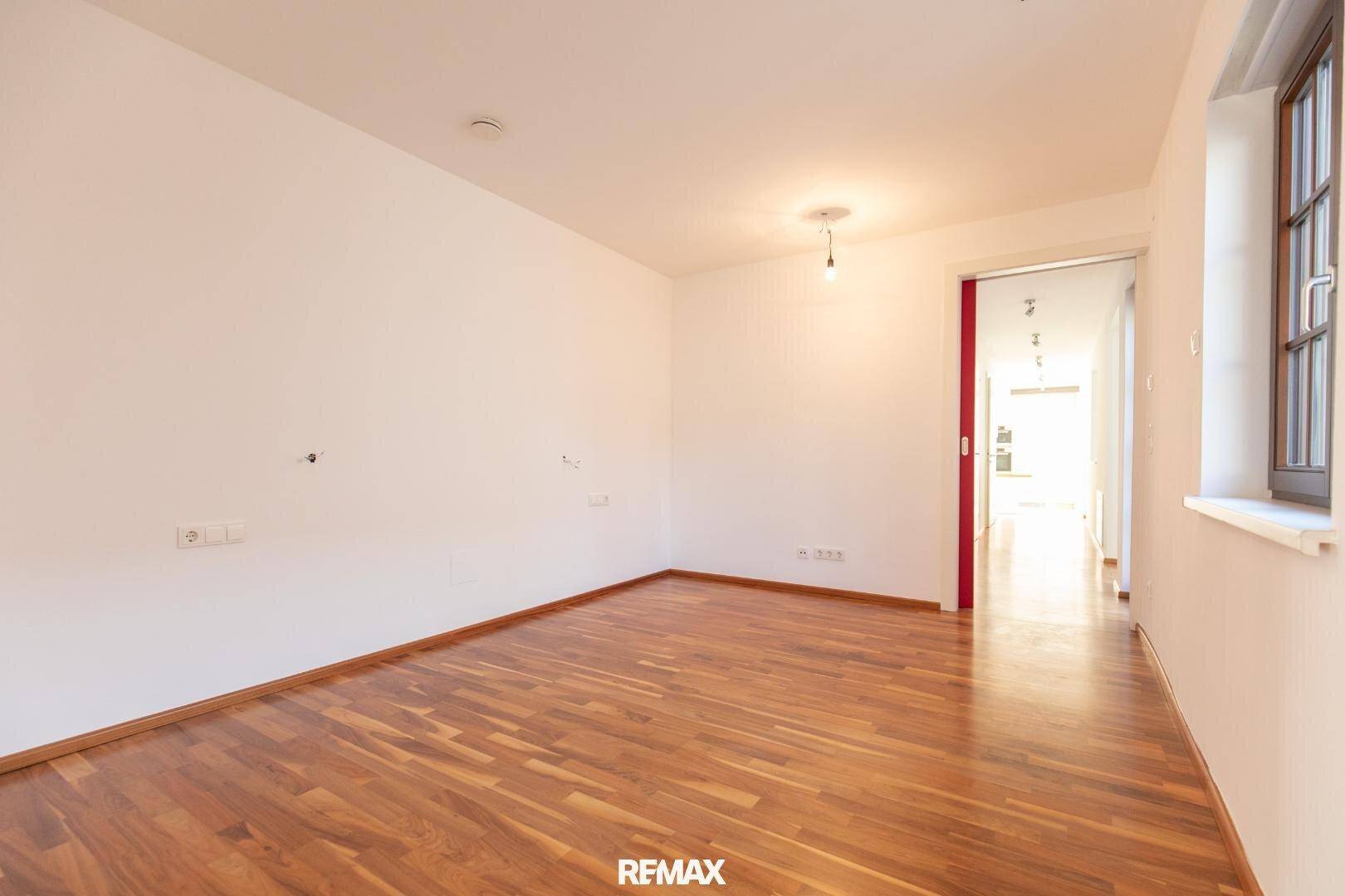 Helles Zimmer mit Parkettboden und Fenster, ideal als Schlafzimmer oder Arbeitszimmer.