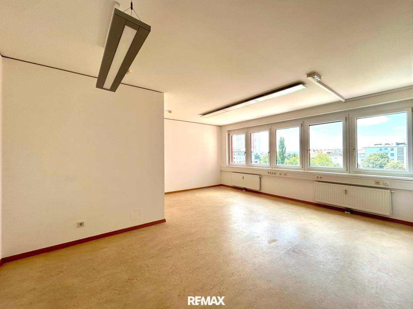 Geräumiges und helles Büro mit mehreren Fenstern und einem strapazierfähigen Bodenbelag.
