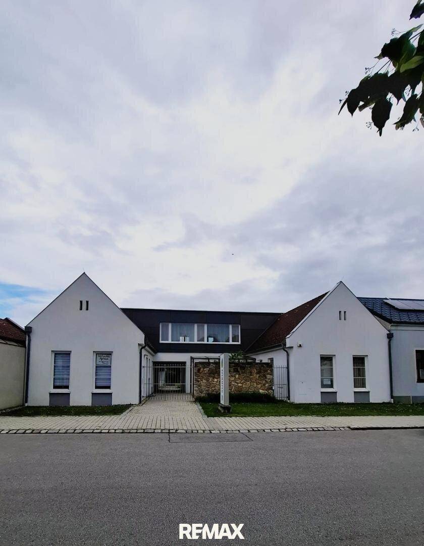 Gesamtansicht des Gebäudes von der Straße aus mit moderner Architektur und gepflegtem Vorplatz.