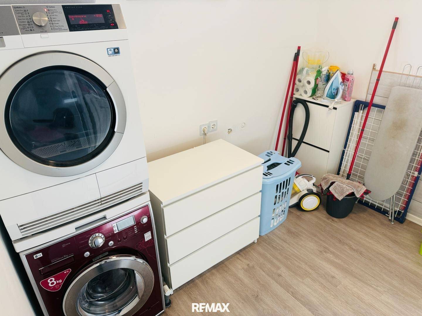 Praktischer Waschraum mit Waschmaschine, Trockner und Stauraum für Haushaltsartikel.