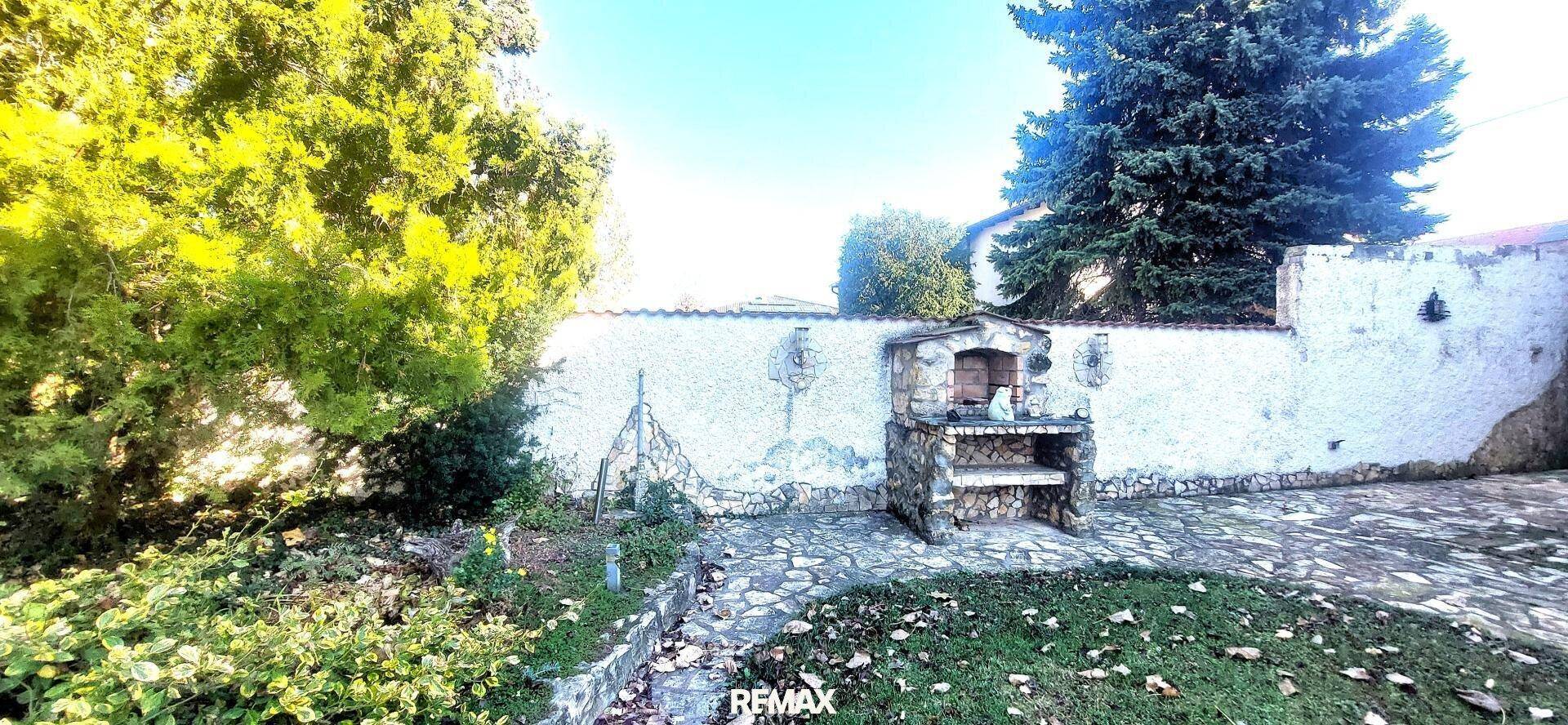 Gemauerter Grillplatz im Garten mit gepflastertem Bereich und umgebendem Grün für gesellige Stunden.