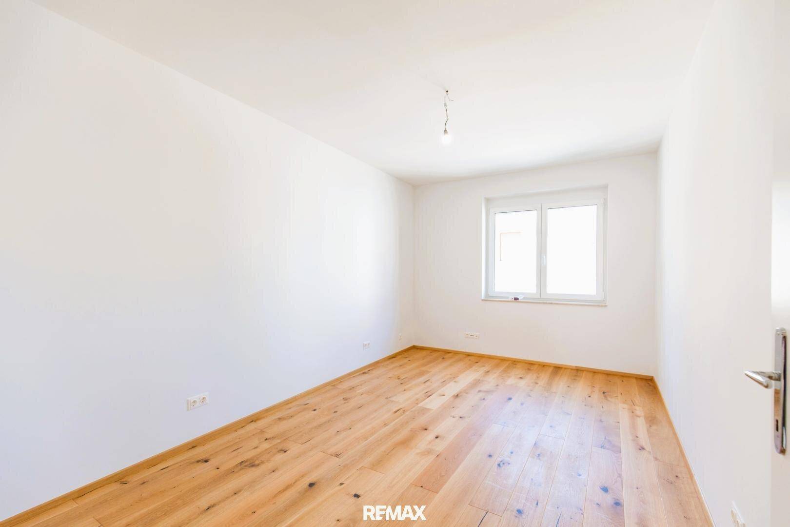 Geräumiges Schlafzimmer mit Holzboden und einem Fenster, ideal für Ruhe und Erholung.