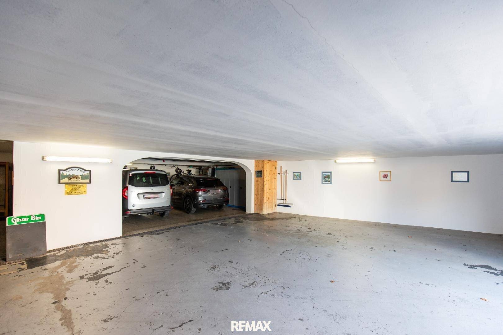 Geräumige Tiefgarage mit Betonboden, Beleuchtung und Platz für mehrere Fahrzeuge.