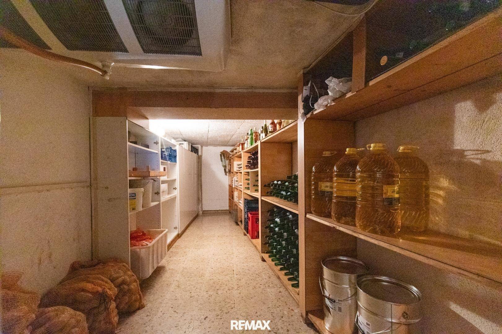 Lagerraum im Keller mit Regalen voller Flaschen, Kanistern und Vorräten.