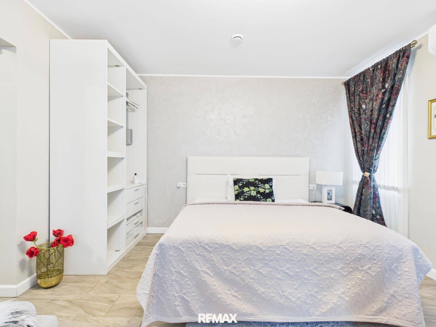 Helles Schlafzimmer mit großem Bett und praktischem, offenem Kleiderschrank.