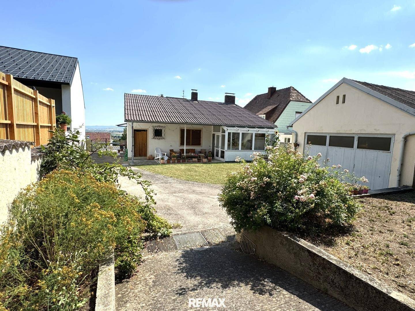 Gesamtansicht des Anwesens mit Haus, Garage und weitläufigem Gartenbereich.