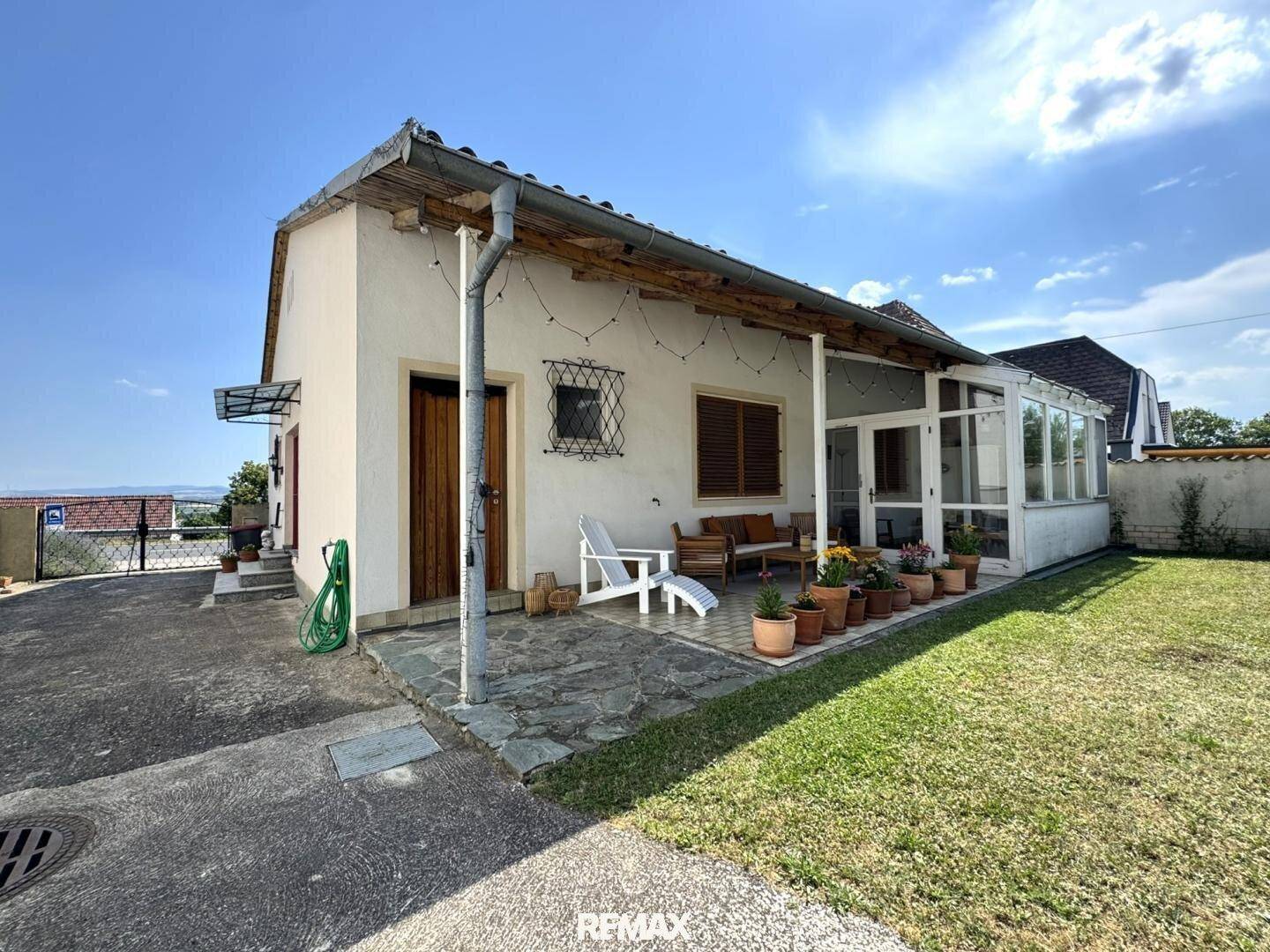 Seitliche Ansicht des Hauses mit Terrasse, Wintergarten und weitläufigem Gartenbereich.