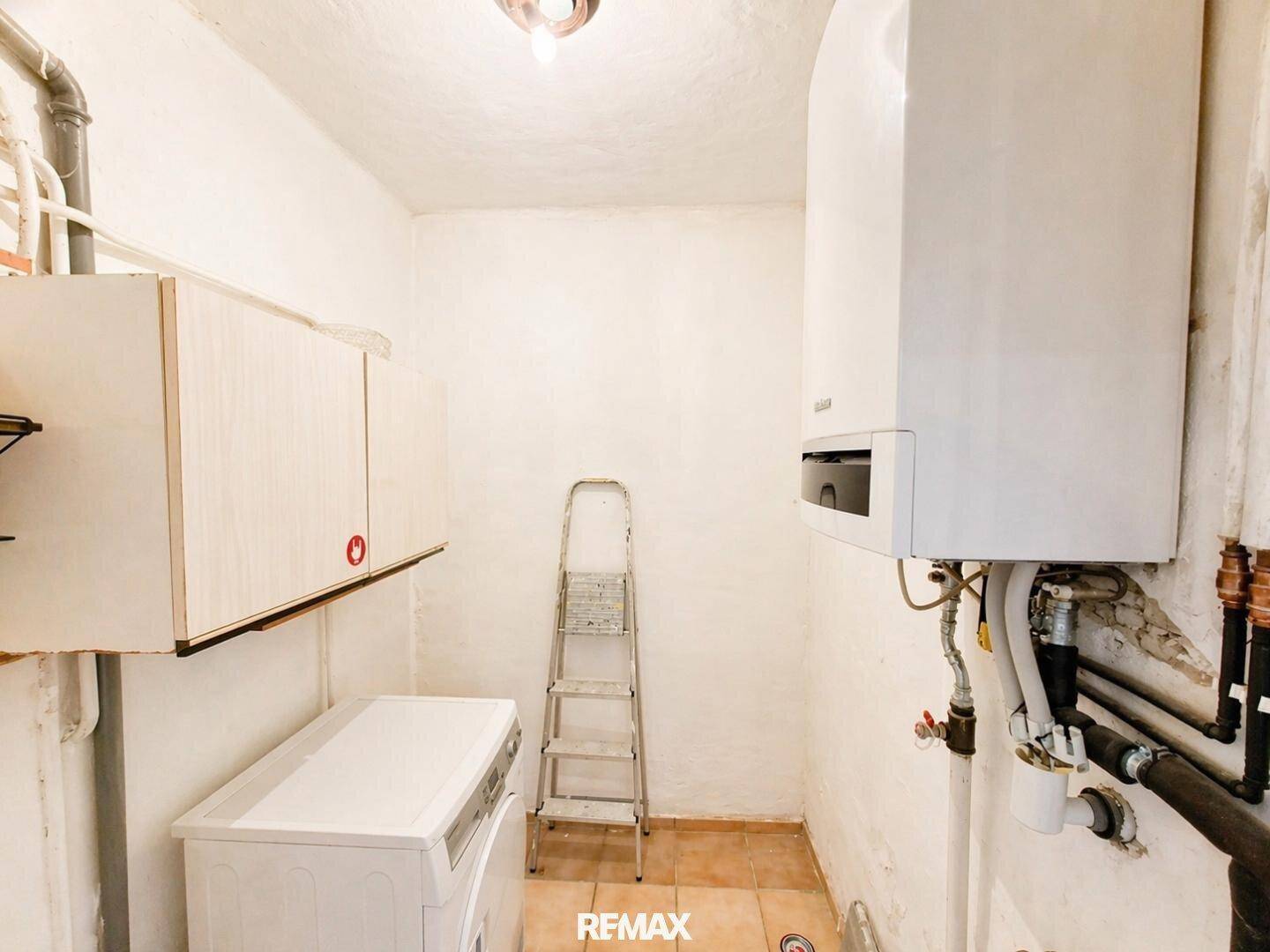 Praktischer Hauswirtschaftsraum mit Heizungsanlage, Waschmaschine und nützlichen Regalen.