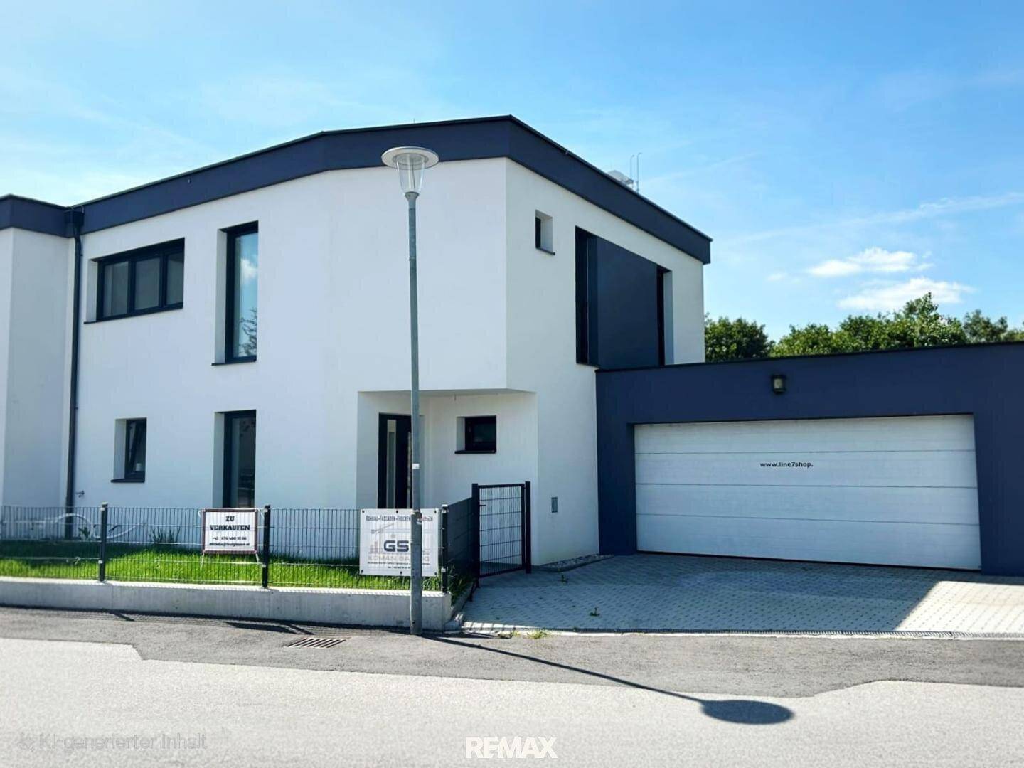 Vorderansicht eines modernen Hauses mit integrierter Garage und weißer Fassade an einem hellen Tag.