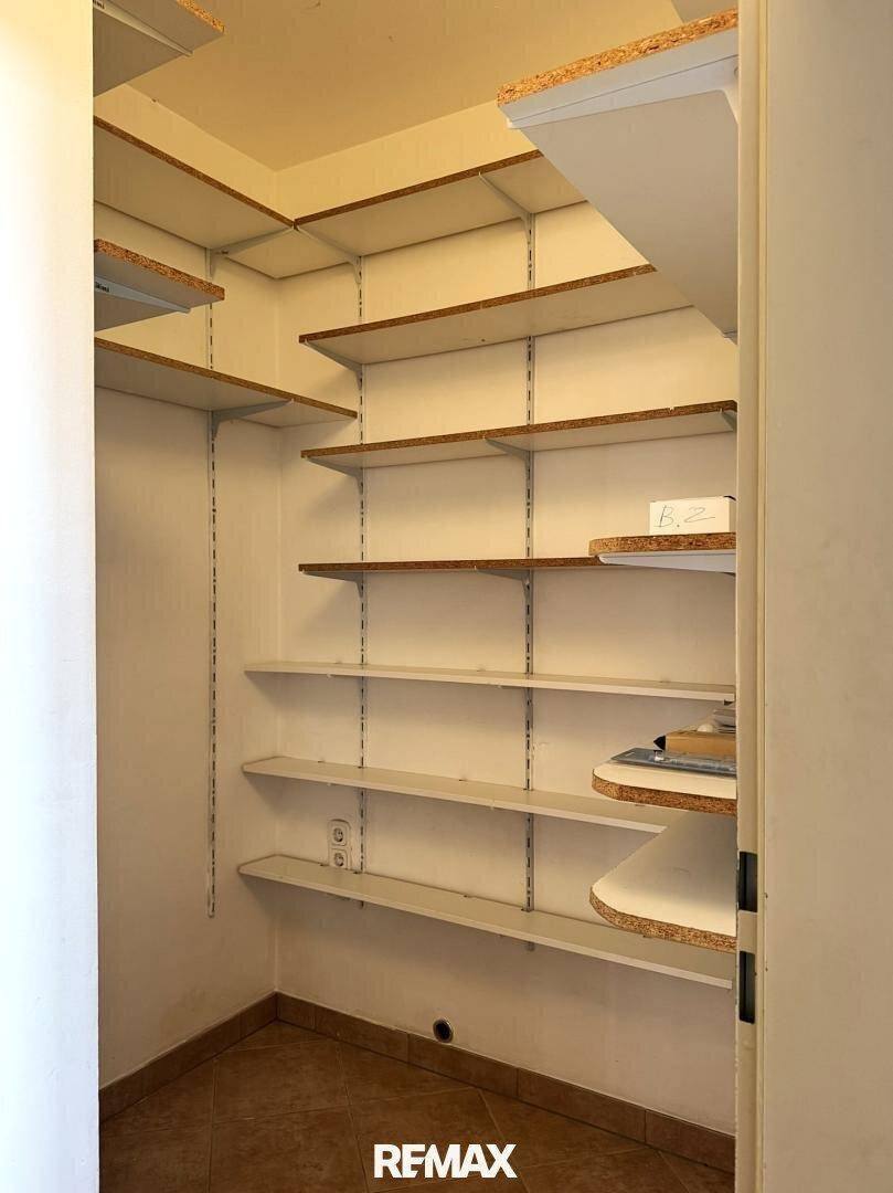 Praktische Speisekammer mit vielen Regalen für zusätzlichen Stauraum und Fliesenboden.