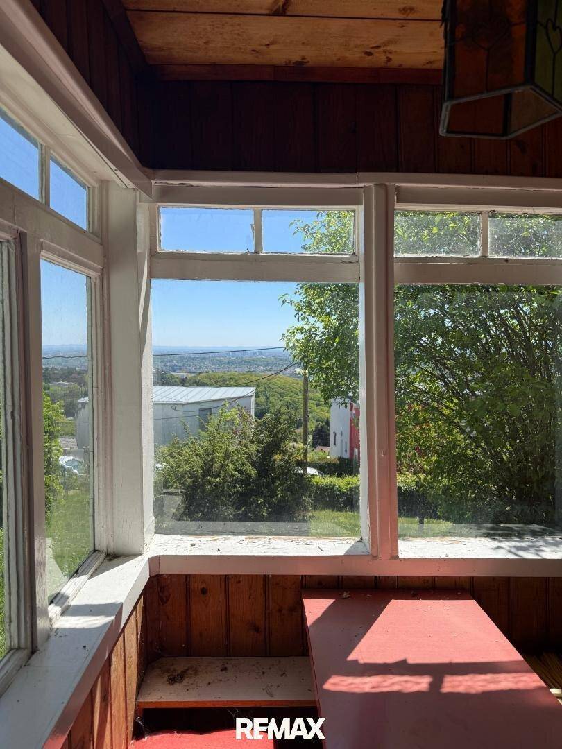 Innenraum mit Holzverkleidung und weitem Blick über die Landschaft durch große Fenster.