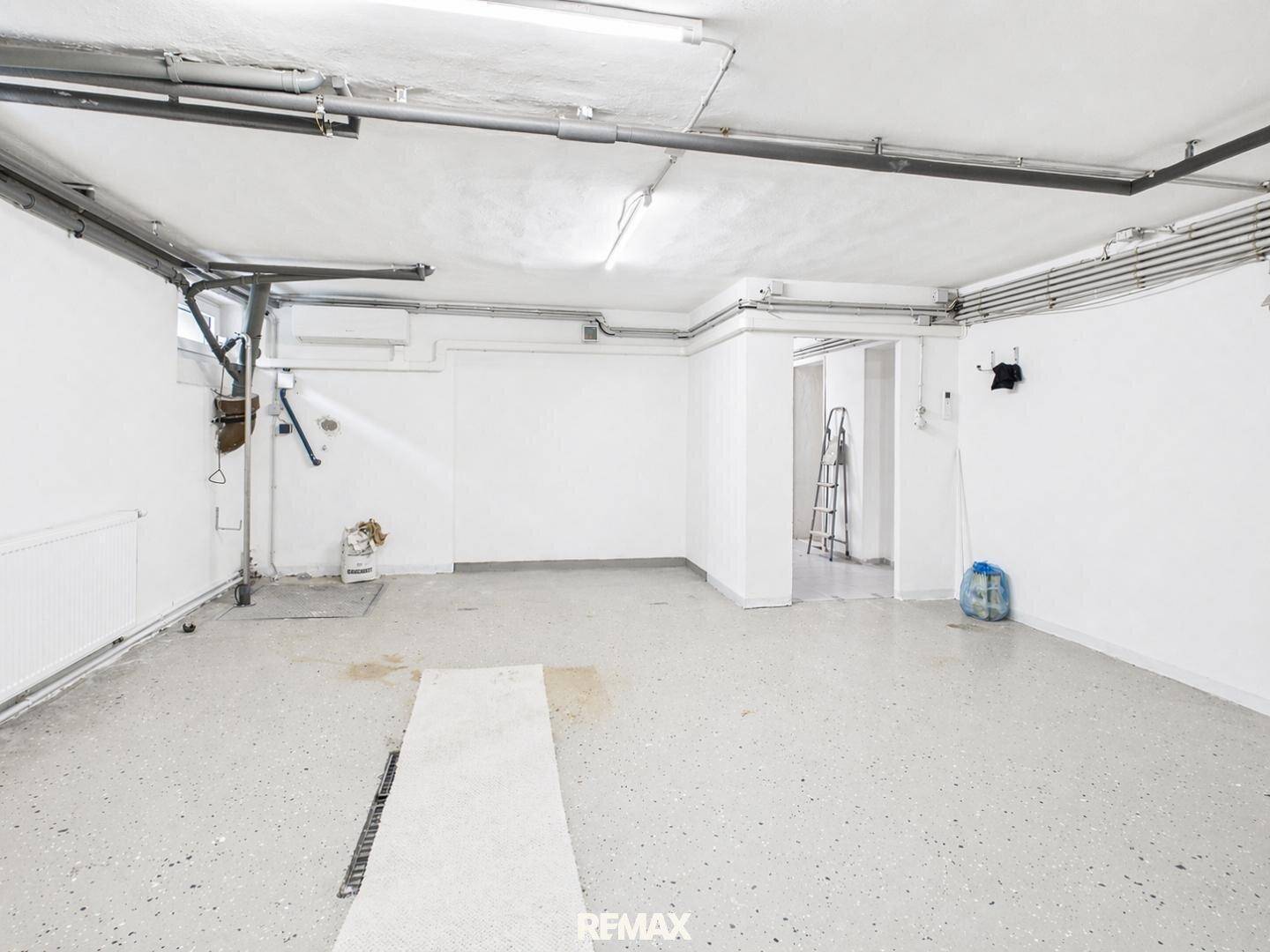 Große Garage mit viel Stauraum und Zugang zu weiteren Bereichen im Untergeschoss.