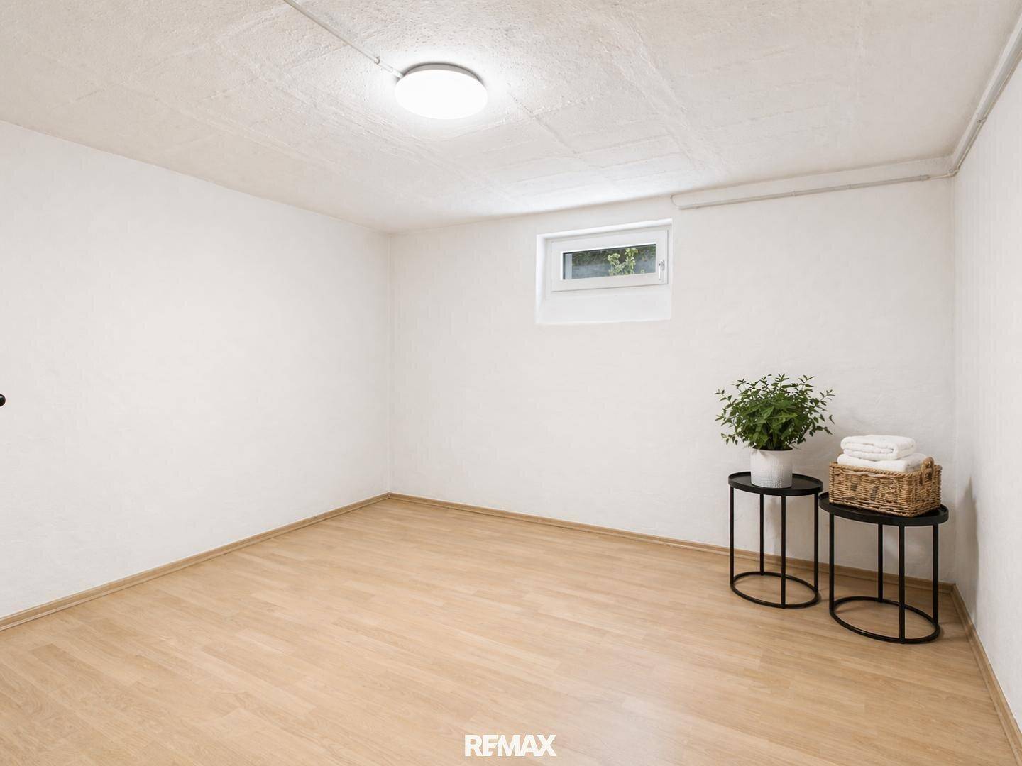 Heller Raum im Untergeschoss mit Laminatboden und kleinem Fenster, vielseitig nutzbar.