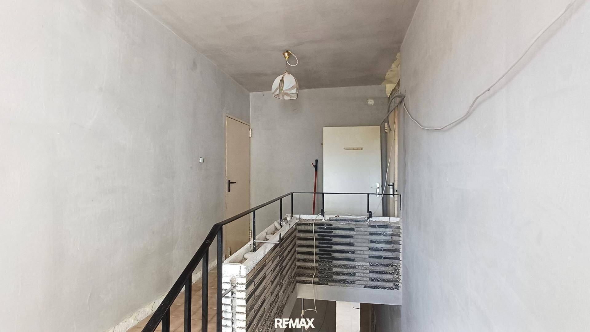 Treppenhaus mit Geländer und Wänden im Rohbau, bereit für den weiteren Ausbau.
