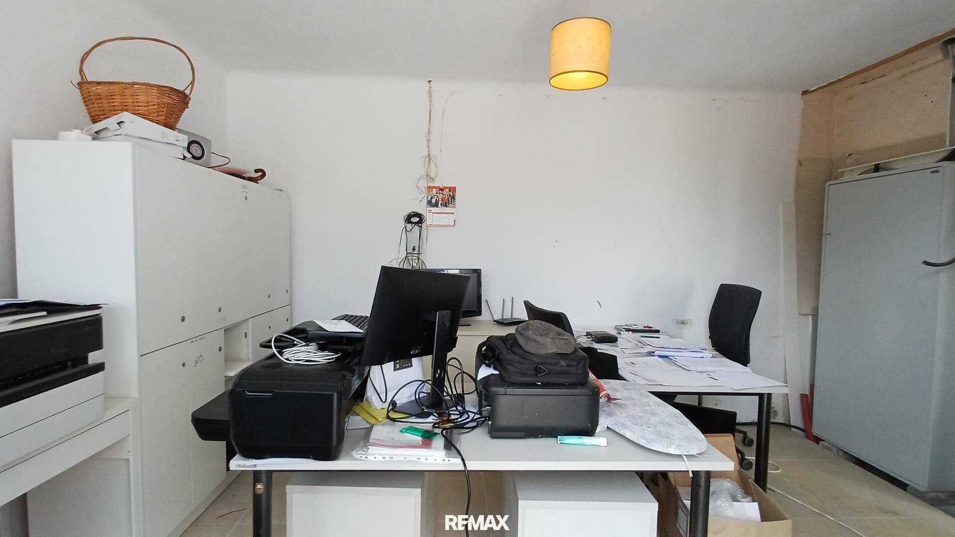 Funktionales Büro mit mehreren Schreibtischen, Computern und Stauraum für Arbeitszwecke.