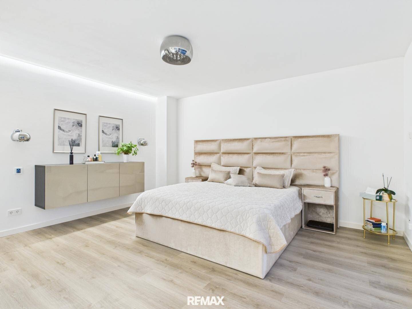 Stilvolles Schlafzimmer mit gepolstertem Kopfteil, schwebenden Nachttischen und indirekter Beleuchtung.