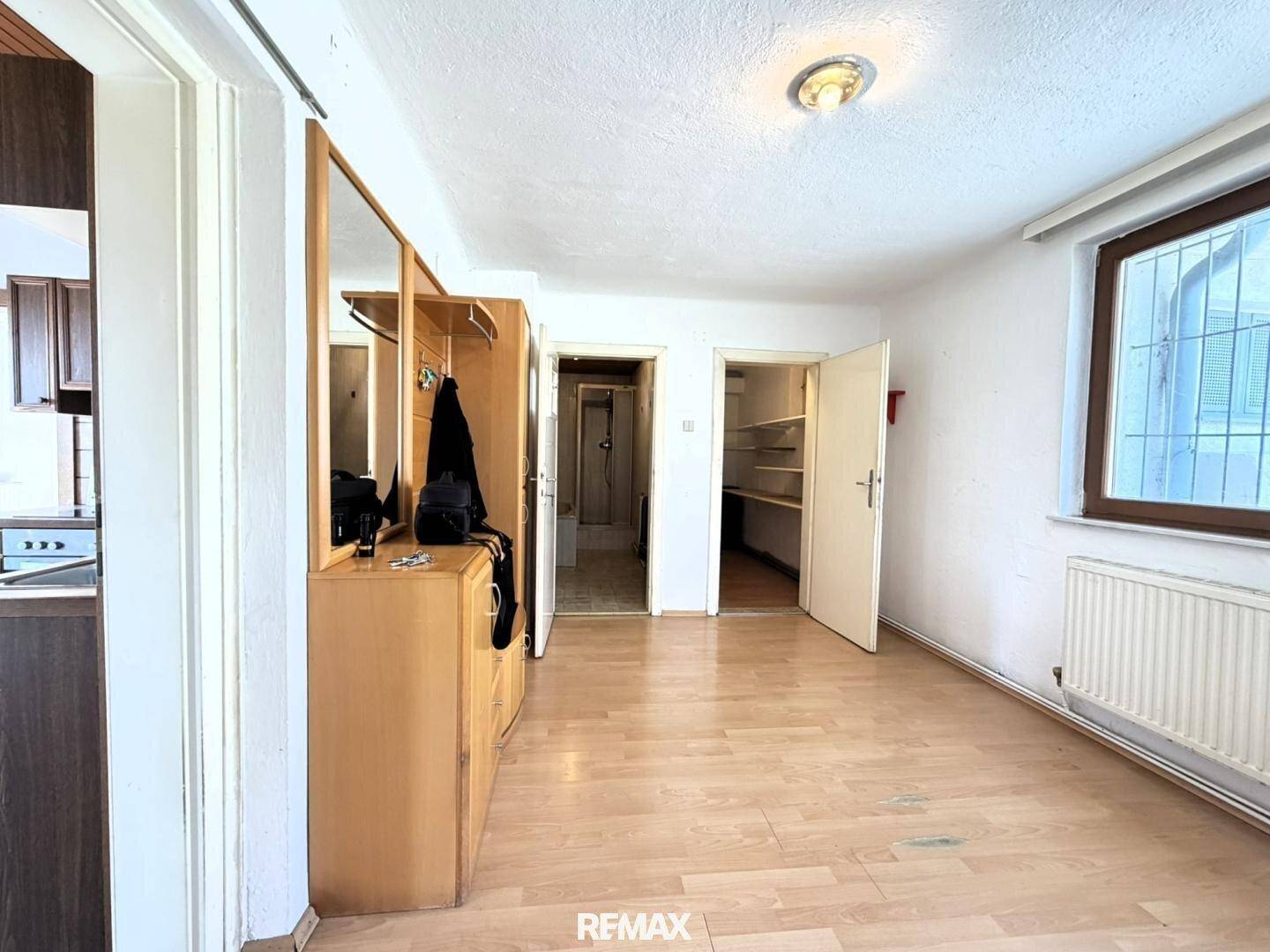 Heller Flur mit Holzfußboden und Garderobe, bietet Zugang zu weiteren Räumen.
