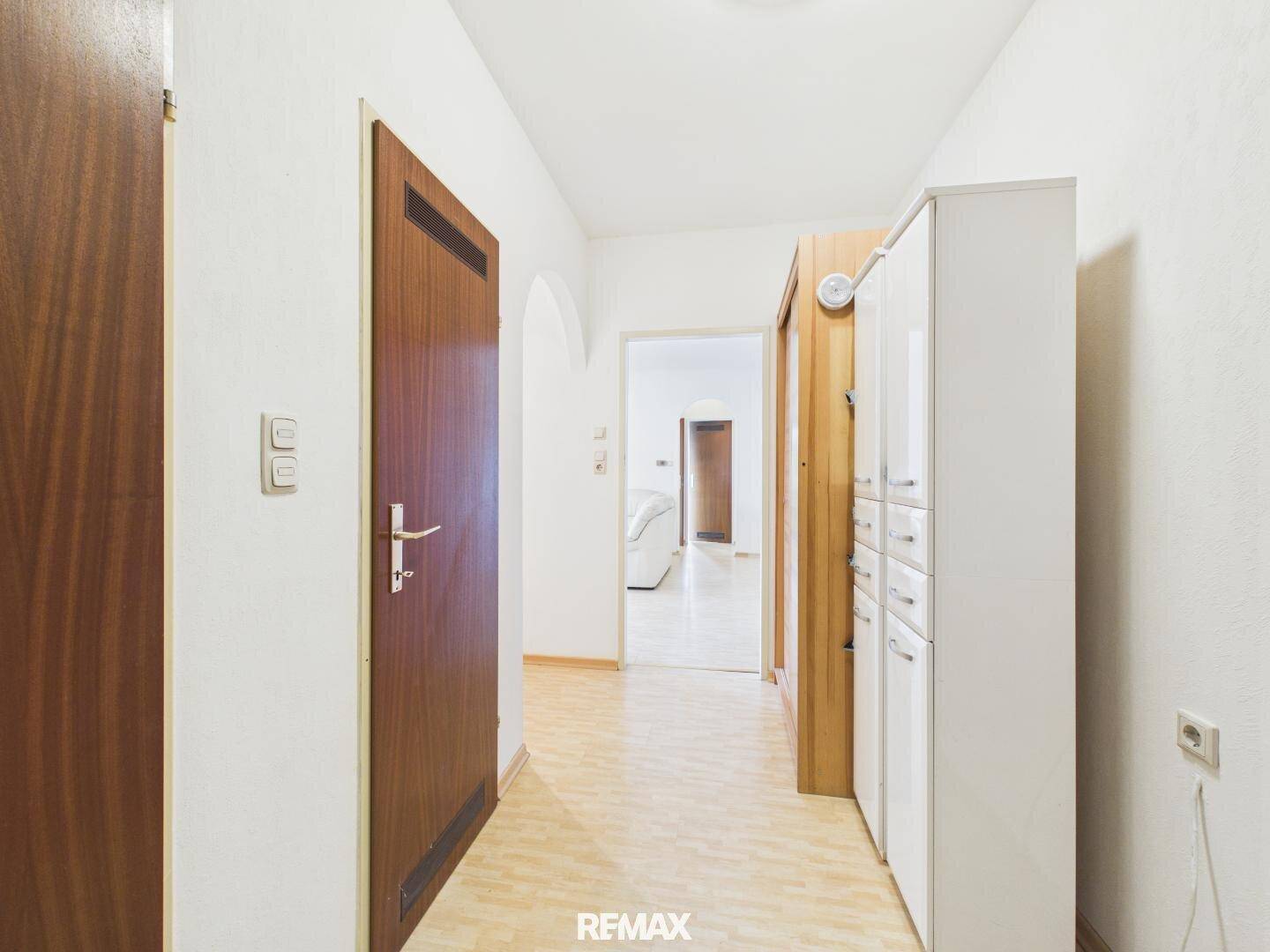 Langer Flur mit Laminatboden und Zugang zu verschiedenen Räumen der Wohnung.