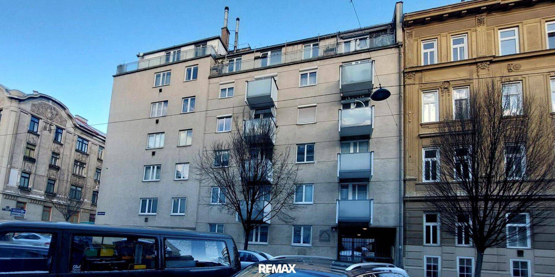 Mehrstöckiges Wohngebäude mit Balkonen und Fenstern an einer städtischen Straße.