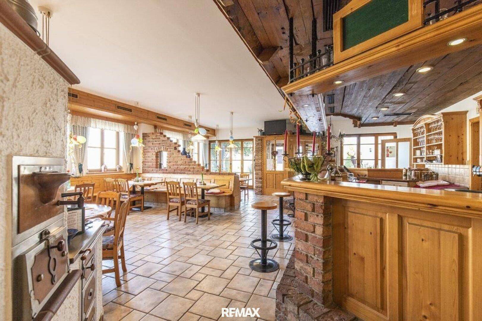 Geräumiger Gastraum mit Bar, Holzbalken und traditioneller Einrichtung, ideal für gesellige Runden.