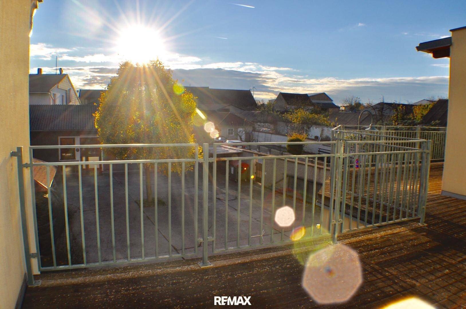 Sonniger Balkon mit Metallgeländer und weitem Blick über die umliegende Bebauung, ideal zum Entspannen.
