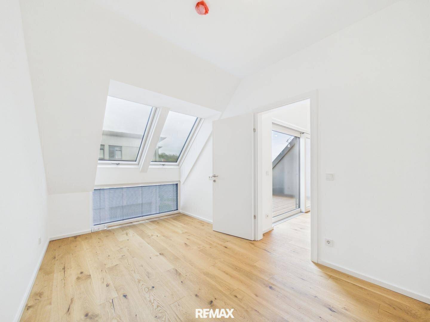 Geräumiges Zimmer mit Holzboden und Dachschrägen, bereit für individuelle Einrichtung.