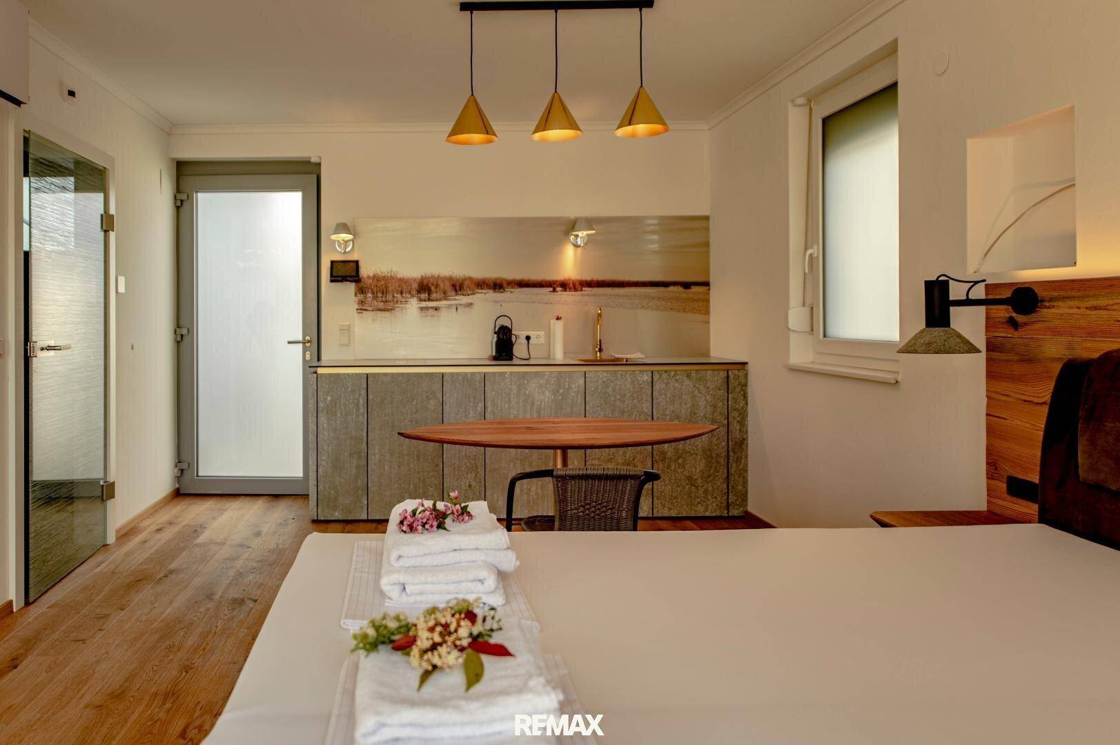 Modernes Studio-Apartment mit integrierter Küchenzeile, Holzboden und viel Tageslicht.