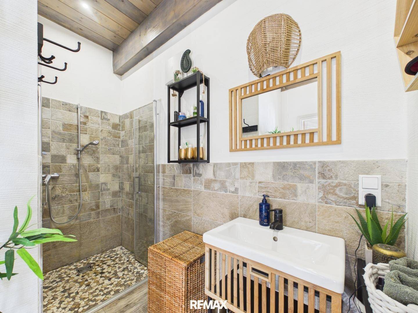Modernes Badezimmer mit begehbarer Dusche, gefliesten Wänden und stilvollem Waschtisch.
