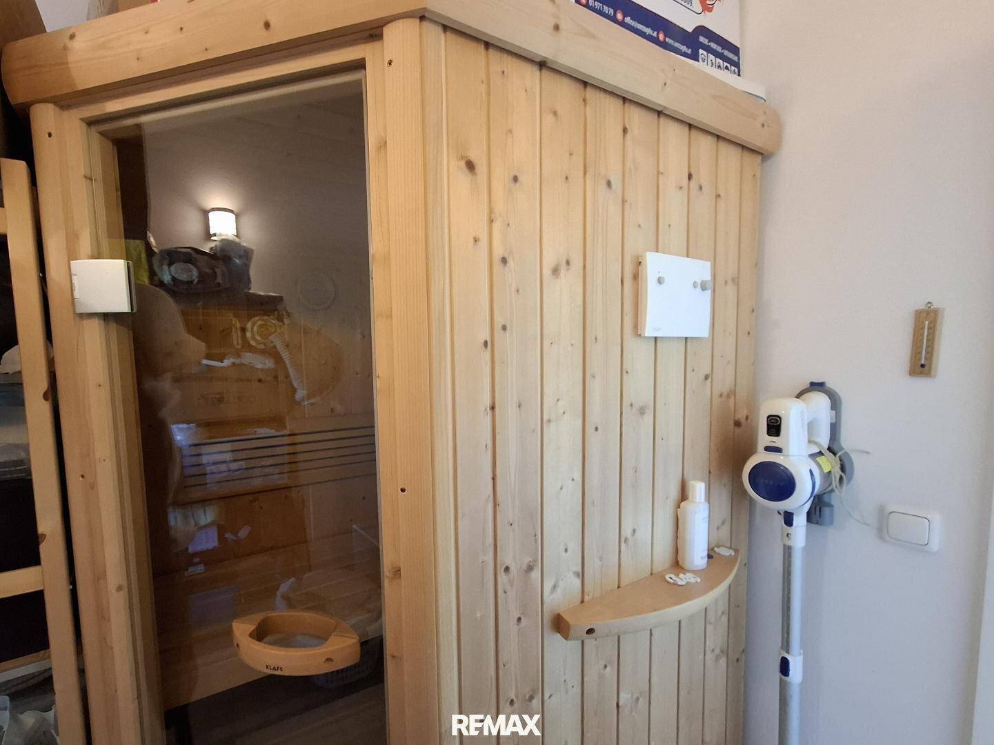 Holzsauna mit Glastür in einem Nebenraum des Hauses.