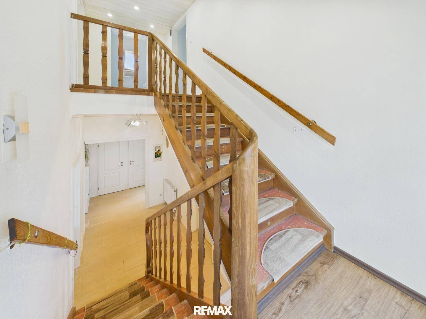 Holztreppe mit gedrechseltem Geländer, die die verschiedenen Ebenen des Hauses miteinander verbindet.