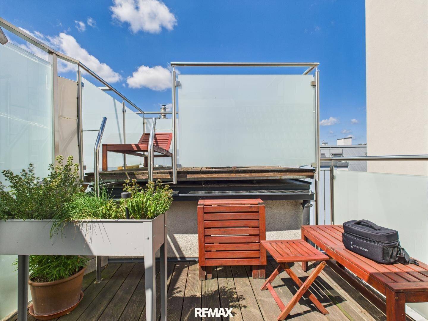 Dachbalkon mit Pflanzenkübeln und Holzboden, bietet einen gemütlichen Außenbereich.