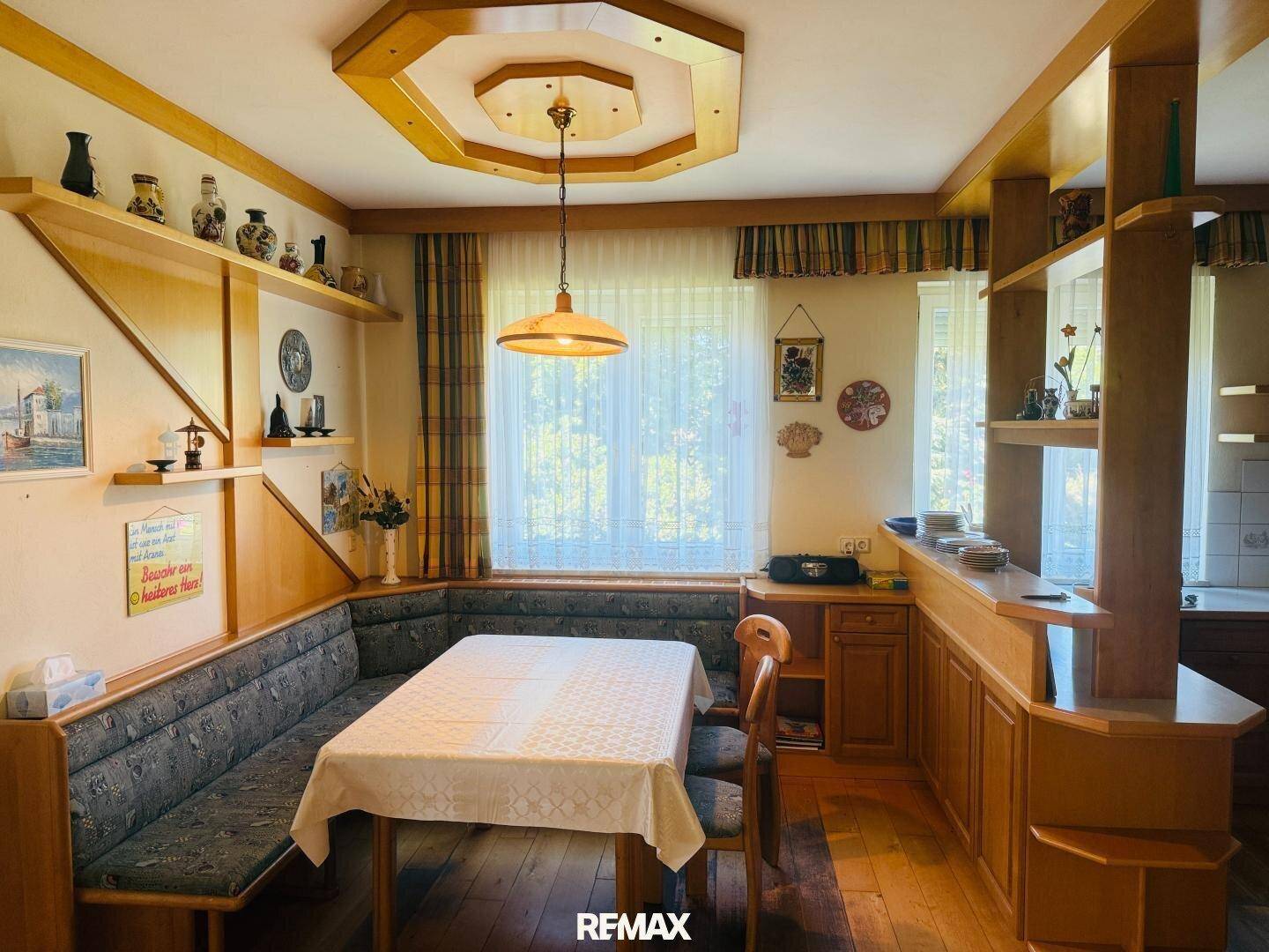 Gemütlicher Essbereich mit Holztisch, Eckbank und traditioneller Deckenverkleidung.