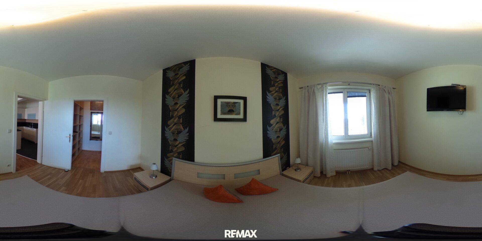 Panoramaansicht des Schlafzimmers mit Doppelbett, Holzboden und Fenster.