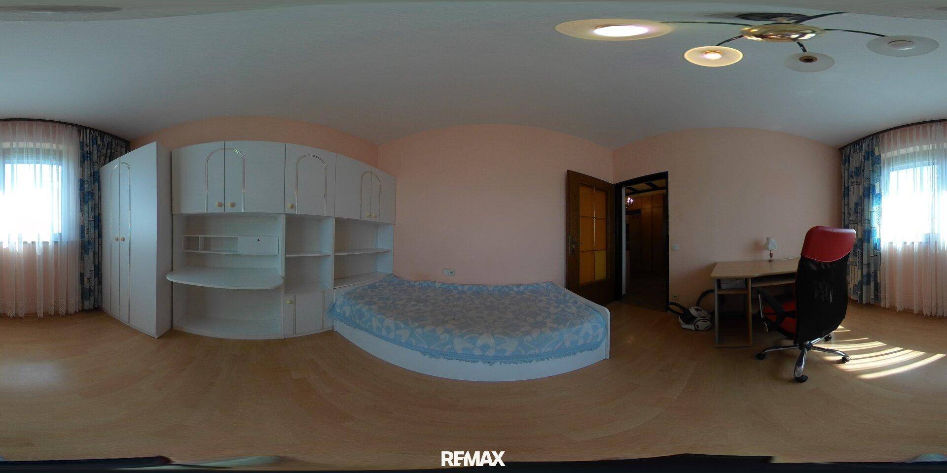 Schlafzimmer mit hellem Holzboden, runder Bettkonstruktion und integrierten weißen Regalen.