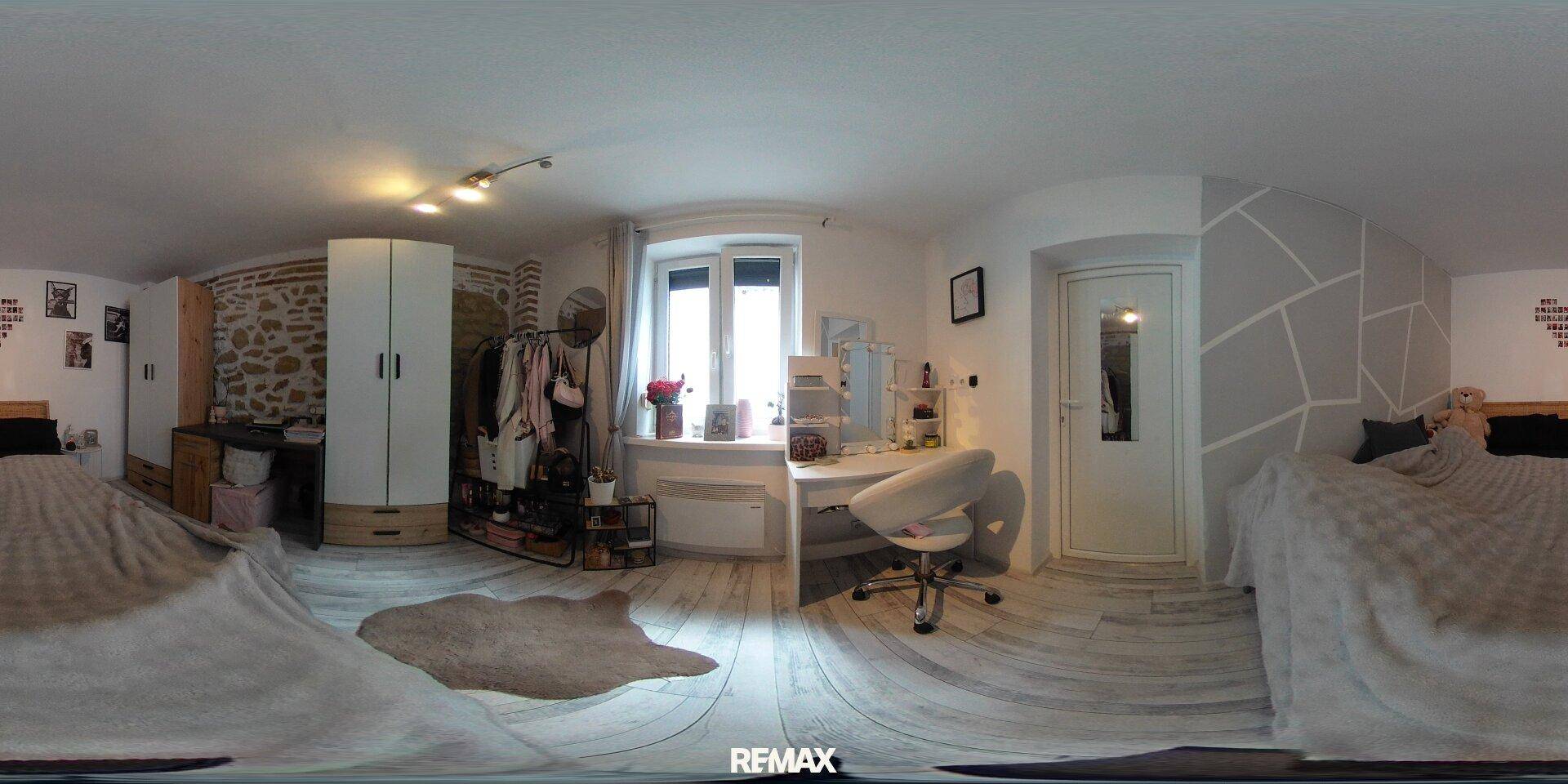 Panoramaansicht des Schlafzimmers mit modernem Wandmuster, Holzboden und Schminktisch.