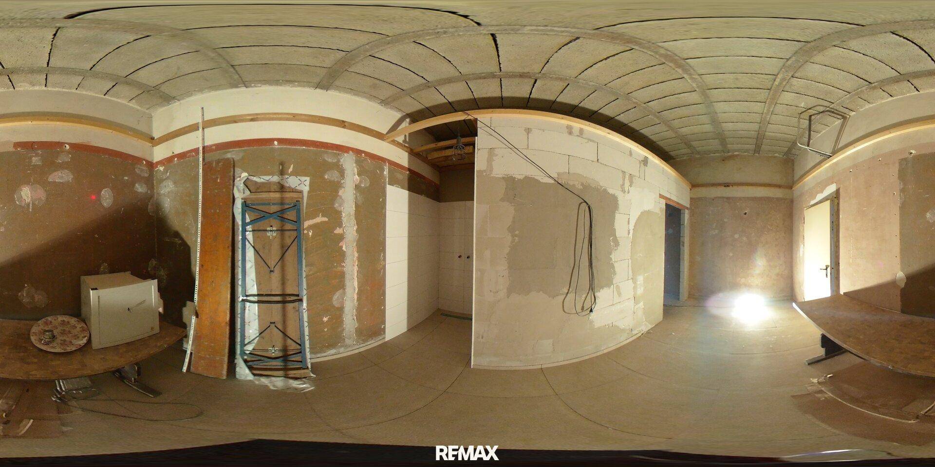 Raum im Rohbau mit unfertigen Wänden und Decken, bereit für den weiteren Ausbau.